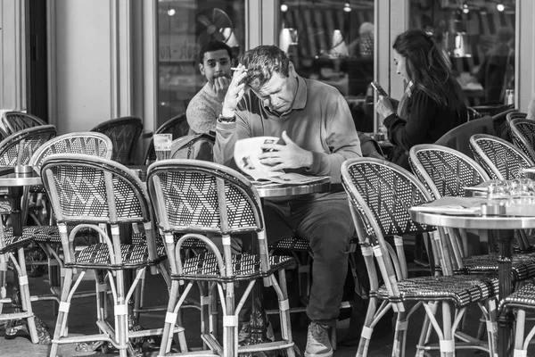 Parijs, Frankrijk, op 27 oktober 2017. Mensen zitten aan een tafeltje van typische café op de Parijse straat in de ochtend. — Stockfoto
