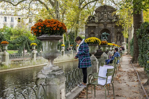 フランス 2017 秋の風景 魅力的な若い女性は リュクサンブール公園でメディチ家の噴水の池にいるアヒルをフィードします — ストック写真