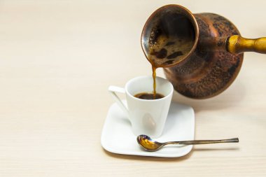 Beyaz porselen fincan espresso kahve üzerinden bir Antik Bakır cezve kahve döktü