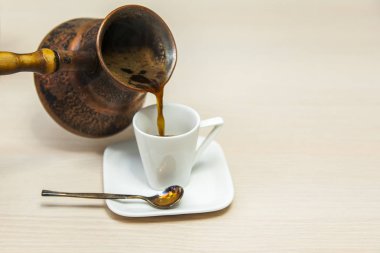Beyaz porselen fincan espresso kahve üzerinden bir Antik Bakır cezve kahve döktü