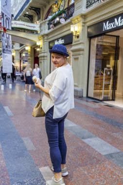 Moskova, Rusya, üzerinde 10 Ağustos 2017. Çekici genç kadın mavi şapka içinde özel dondurma tarihi salonu sakız ticaret galeride yiyor.