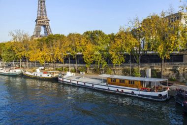 Paris, Fransa, üzerinde 30 Ekim 2017. Sonbahar şehir manzarası. Gün batımı Seine Nehri ve onun bentleri bilir. İnsanlı mavnalar kıyıya demirlemiş. Eyfel Kulesi'ne mesafe
