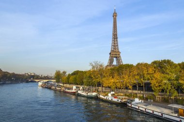 Paris, Fransa, üzerinde 30 Ekim 2017. Sonbahar şehir manzarası. Gün batımı Seine Nehri ve onun bentleri bilir. İnsanlı mavnalar kıyıya demirlemiş. Eyfel Kulesi'ne mesafe
