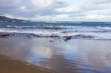 Pitoresk dalgalar sahil kumlu plajda sörf sırasında yıkayın.