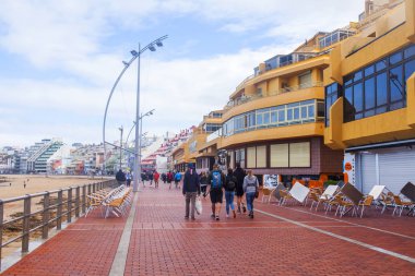 Las Palmas de Gran Canaria, İspanya, 6 Ocak 2018 üzerinde. Playa de Las Canteras plaja yakın dolgu yürüyüşte insanlar Kış Güneşi ile yaktı.
