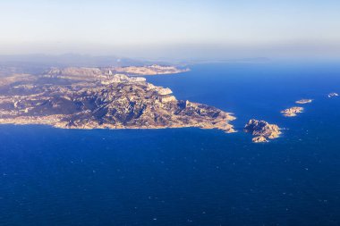 Deniz kıyısı bir sis içinde engebeli arazide. Büyük yükseklikte uçan uçak penceresinden bir görünüm