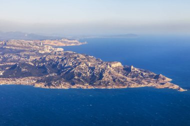 Deniz kıyısı bir sis içinde engebeli arazide. Büyük yükseklikte uçan uçak penceresinden bir görünüm