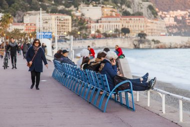 Güzel, Fransa, üzerinde 10 Mart 2018. Tarihsel Promenade des Anglais, en güzel bir görünümünü bir desen ile günbatımı güneş yaktı. İnsanlar biraz dinlen ve deniz hayranım