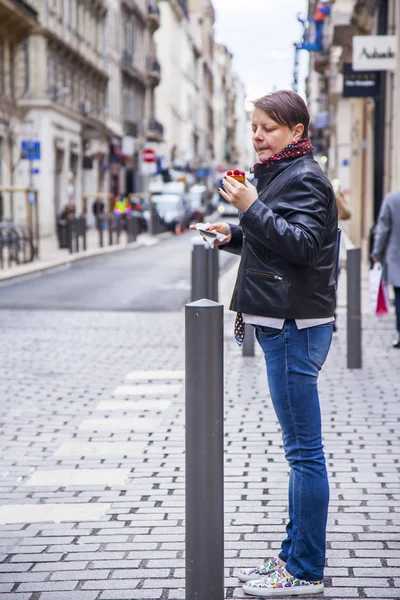 MARSEILLE, FRANCE, on March 2, 2018. The young attractive woman eats cake on the street