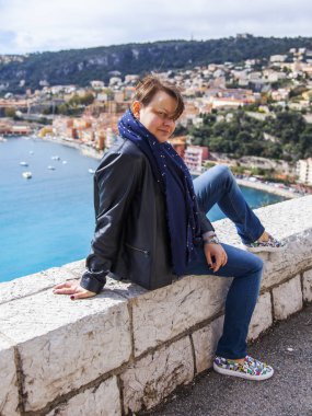 Villefranche-sur-Mer, Fransa, 6 Mart 2018. Genç çekici kadın güzel bir koyda arka planı teşkil etmektedir.