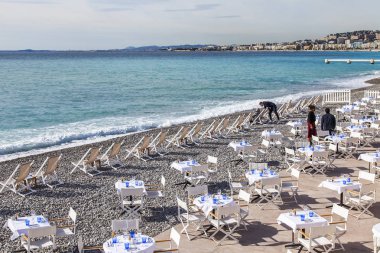 Güzel, Fransa, 7 Mart 2018. Bir su kenarında kumsalda beyaz küçük tablolar pitoresk Kafe'nin yerleşti