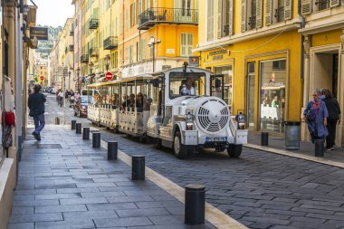 Güzel, Fransa, 8 Ekim 2019. Eski kasabadaki güzel resimli cadde. Mimari topluluk Provence bölgesinin tipik bir örneğidir. Turist treni yolda ilerliyor..