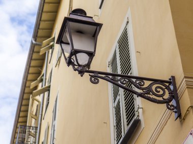Güzel, Fransa, 10 Ekim 2019. Provence bölgesinin tipik mimarisi. Eski şehirdeki binanın ön cephesinin bir parçası. Binada güzel bir sokak lambası