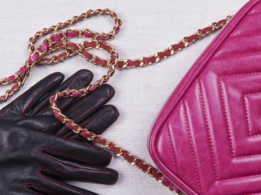 Pembe kadın çantasının parçaları ve siyah eldivenleriyle yatıyordu.
