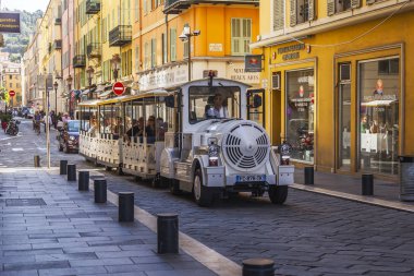 Güzel, Fransa, 8 Ekim 2019. Eski kasabadaki güzel resimli cadde. Mimari topluluk Provence bölgesinin tipik bir örneğidir. Turist treni yolda ilerliyor..