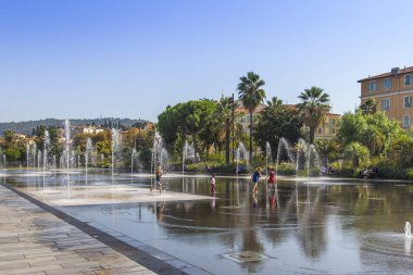Nice, France, October 9, 2019. Picturesque Park Paillon Promenade. A dancing fountain adorns the alley. Kids play with water. clipart