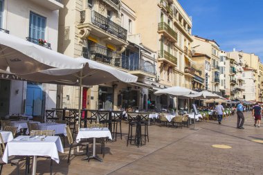 Cannes, Fransa, 8 Ekim 2019. Eski kasabanın pitoresk caddesindeki geleneksel bir sokak kafesinin masaları..