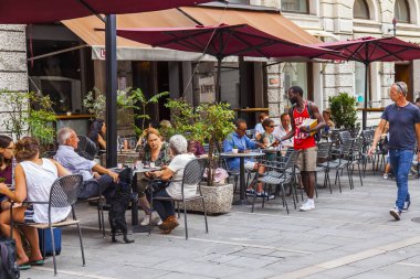 Trieste, İtalya, 5 Ağustos 2019. Tarihi şehirde pitoresk bir caddenin kaldırımında çekici kafe masaları.