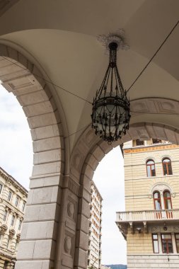 Trieste, İtalya, 5 Ağustos 2019. Eski şehirdeki tipik bir binanın ön cephesinin bir parçası. Güzel sokak lambası