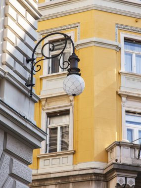 Trieste, İtalya, 5 Ağustos 2019. Eski şehirdeki tipik bir binanın ön cephesinin bir parçası. Güzel sokak lambası