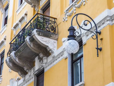 Trieste, İtalya, 5 Ağustos 2019. Eski şehirdeki tipik bir binanın ön cephesinin bir parçası. Güzel sokak lambası