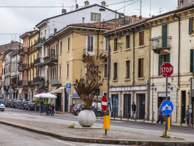 Verona, İtalya, 24 Nisan 2019 tarihinde. İnsanlar eski şehirde dar pitoresk sokak boyunca gitmek