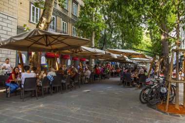 Trieste, İtalya, 5 Ağustos 2019. Tarihi şehirde pitoresk bir caddenin kaldırımında çekici kafe masaları.