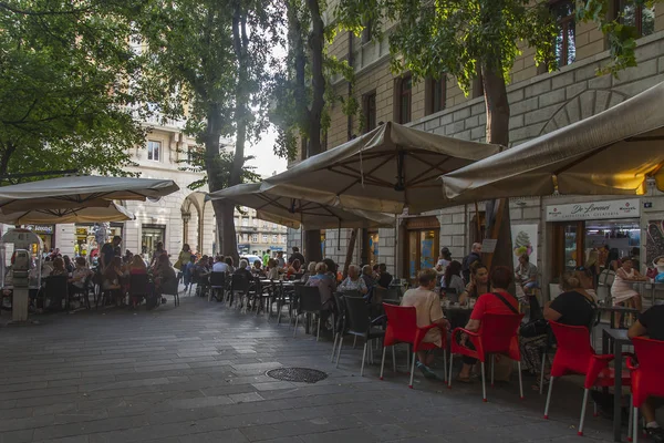 Trieste, İtalya, 5 Ağustos 2019. Tarihi şehirde pitoresk bir caddenin kaldırımında çekici kafe masaları.