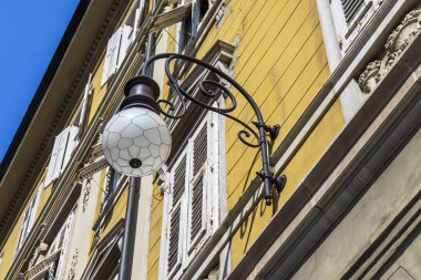 Trieste, İtalya, 5 Ağustos 2019. Eski şehirdeki tipik bir binanın ön cephesinin bir parçası. Güzel sokak lambası