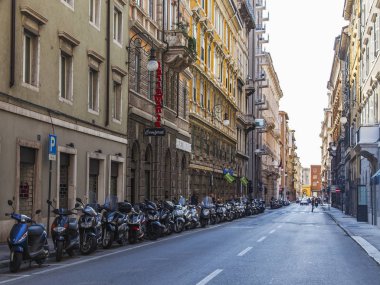 Trieste, İtalya, 5 Ağustos 2019. Tarihi şehirde güzel bir resim caddesi. Arabalar ve motosikletler kaldırımın kenarına park edilmiş.