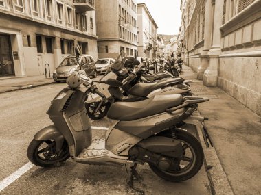 Trieste, İtalya, 5 Ağustos 2019. Tarihi şehirde güzel bir resim caddesi. Arabalar ve motosikletler kaldırımın kenarına park edilmiş.