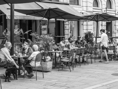 Trieste, İtalya, 5 Ağustos 2019. Tarihi şehirde pitoresk bir caddenin kaldırımında çekici kafe masaları.