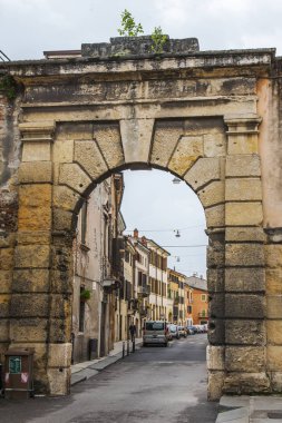 Verona, İtalya, 24 Nisan 2019. Şehir merkezinin tarihi bölümünde taş kemerli dar resimli cadde. Tipik şehir silüeti