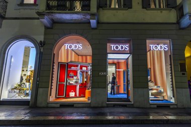 Milan, İtalya, 12 Şubat 2020. Şehir merkezindeki alışveriş caddesinde akşam aydınlığında. Çok sayıda mağaza akıllı vitrinli müşterileri çekiyor.