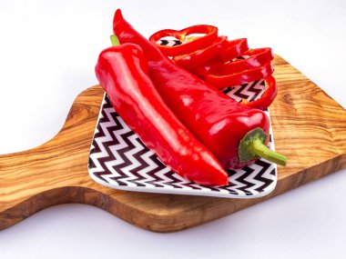 Masanın üzerinde dikdörtgen bir tabakta kırmızı biber var.