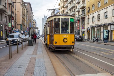 Milan, İtalya, 12 Şubat 2020. Tarihi bir binada şehrin bir caddesinde klasik bir tramvay.