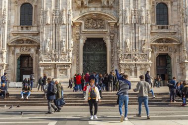 Milan, İtalya, 12 Şubat 2020. Şehrin ilgi odağı katedraldir (İtalyanca: Duomo di Milano veya Cattedrale di Santa Maria Nascente). İnsanlar Duomo 'nun önünde meydanda yürüyor..