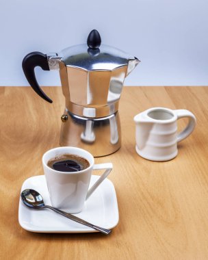 Kahve için masayı hazırla. Gayzer kahve makinesi, süt sürahisi, fincan ve çay tabağı.