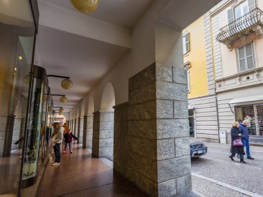 Lecco, İtalya, 16 Şubat 2020. Tarihi bir binada tipik şehir manzarası. İnsanlar güzel bir caddede yürüyorlar.