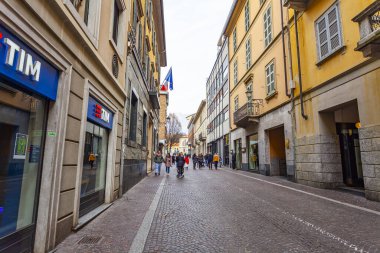Lecco, İtalya, 16 Şubat 2020. Tarihi bir binada tipik şehir manzarası. İnsanlar güzel bir caddede yürüyorlar.