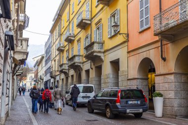 Lecco, İtalya, 16 Şubat 2020. Tarihi bir binada tipik şehir manzarası. İnsanlar güzel bir caddede yürüyorlar.