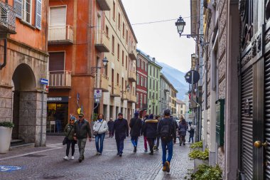 Lecco, İtalya, 16 Şubat 2020. Tarihi bir binada tipik şehir manzarası. İnsanlar güzel bir caddede yürüyorlar.