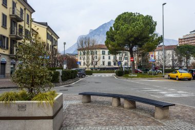 Lecco, İtalya, 16 Şubat 2020. Tarihi bir binada tipik şehir manzarası. İnsanlar güzel bir caddede yürüyorlar.