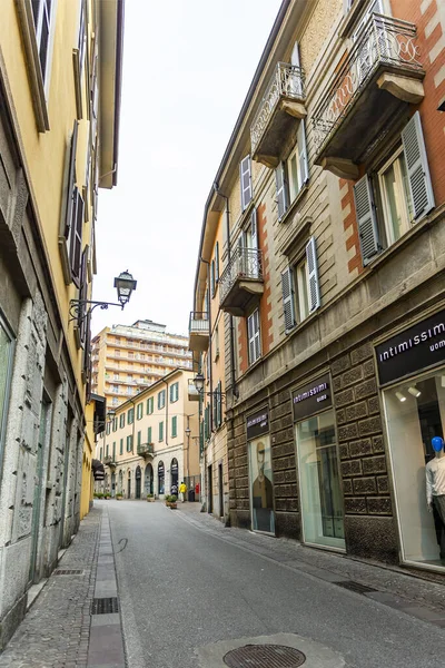 Lecco, İtalya, 16 Şubat 2020. Tarihi bir binada tipik şehir manzarası. İnsanlar güzel bir caddede yürüyorlar.