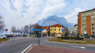 Lecco, İtalya, 16 Şubat 2020. Tarihi bir binada tipik şehir manzarası. İnsanlar güzel bir caddede yürüyorlar.
