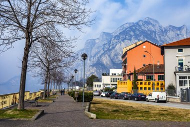 Lecco, İtalya, 16 Şubat 2020. Tarihi bir binada tipik şehir manzarası. İnsanlar güzel bir caddede yürüyorlar.
