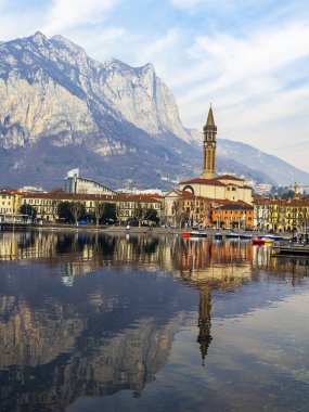 Lecco, İtalya, 16 Şubat 2020. Como Gölü 'nün bulutlu havadaki manzaralı seti ve arkasındaki dağlar. Suda güzel bir yansıma
