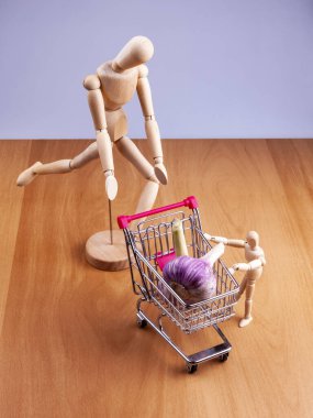 Alışveriş arabalarında taze sarımsak ve iki insan modeli.