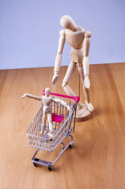Bir alışveriş arabası ve iki insan modeli.