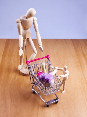 Alışveriş arabalarında taze sarımsak ve iki insan modeli.